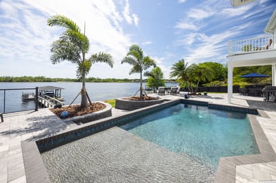 hardscape pavers pool decking with palm trees outdoor furniture waterfront view 10